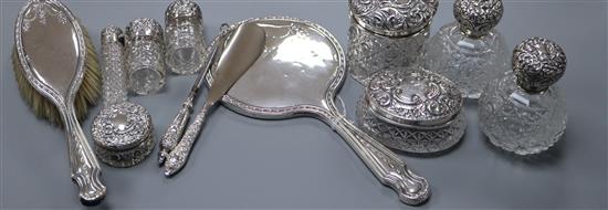 Seven assorted late Victorian and later silver mounted toilet jars/scent bottles and a silver hand mirror, brush etc.